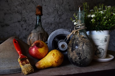 花瓶旁边的花盆和水果在桌子上
